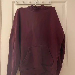Vinröd hoodie från BikBok XS - Mysig vinröd hoodie från BikBok i storlek XS. Tröjan har huva med snörning, magficka och är tillverkad i mjuk bomullsblandning. Perfekt för chill dagar och snygg till jeans eller leggings. Vinröd bikbok hoodie i st xs andvänd ett fåtal gånger och säljs pga att jag har för många hoodies så den kommer inte till andväning längre.