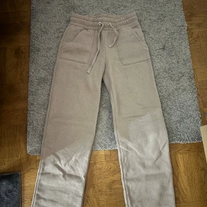 Beige mjukisbyxor med snörning, S - Beiga mjukisbyxor från 157 i storlek S. Byxorna har resår och snörning i midjan, stora fickor fram och bak samt raka ben. Perfekta för chill dagar och riktigt sköna tack vare mjukt material. Säljes då de inte kommer till användning alls 