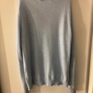 Ljusblå stickad tröja från Vila - Mysig ljusblå stickad tröja från Vila med rund hals och ribbade muddar vid ärmslut och nederkant. Tröjan har en enkel och clean look, perfekt att matcha med jeans eller kjol. Långärmad och i mjukt material som känns skönt mot huden.