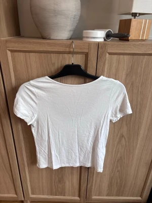 Vit topp - Säljer en enkel och stilren vit  topp från 157. Toppen har en öppning i ryggen storlek 160