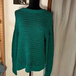 Grön stickad tröja från C - Säljer en grön stickad tröja från C i storlek S. Tröjan har ett ribbat mönster och är långärmad med rund hals. Perfekt för dig som gillar en chill och enkel stil. Passar dig som vill ha något mjukt och bekvämt till hösten eller vintern.