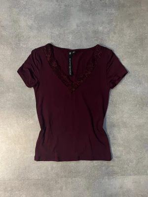 Burgundy topp med spets 🤍 nyskick (XS) - Säljer en helt ny vinröd topp med fin spetsdetalj i V-ringningen ✨ Aldrig använd.  • Storlek: XS • Färg: Vinröd / burgundy • Skick: 10/10 – nytt skick • Kortärmad, figurnära passform • Mjukt och stretchigt material  Superfin både till vardag och fest – passar perfekt till jeans, kjol eller kostymbyxor 💃 Säljs pga garderobsrensning.  📦 Skickas snabbt 🚭 Rök- och djurfritt hem 💬 Pris kan diskuteras vid snabb affär