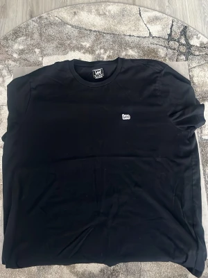 Svart Lee t-shirt  - Svart t-shirt från Lee i klassisk modell med rund hals och korta ärmar. Diskret Lee-logga broderad på bröstet. T-shirten är gjord i mjuk bomull och har en clean, enkel look som funkar till jeans eller shorts. Helt ny! 10/10 skick.