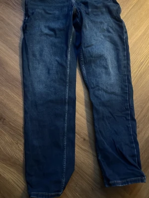 Levi's Loose Taper jeans mörkblå - Mörkblå jeans från Levi's med loose taper passform. Klassisk femficksdesign, gul kontrastsöm och knappgylf. Jeansen har en avslappnad siluett med avsmalnande ben och är tillverkade i slitstarkt denimtyg. Perfekt för dig som gillar en chill och modern look.