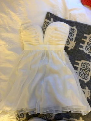 Vit klänning - Superfin kort klänning med strass vid bysten! Har en osynlig dragkedja på sidan för att få på den🥰Passar XS men även S