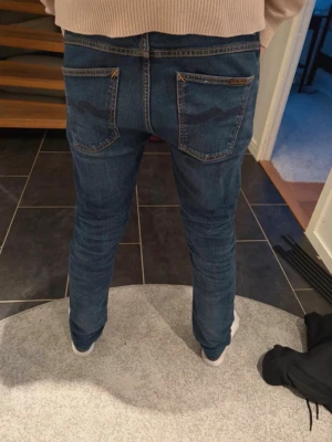 Nudie Jeans  dude dan W29/L31 - Säljer ett par mörkblå Nudie Jeans  (dude dan) Jeansen har  en lite smalare  passform och är  tillverkade i stretchig bomullsdenim för extra komfort. PRISET KAN DISKUTERAS !
