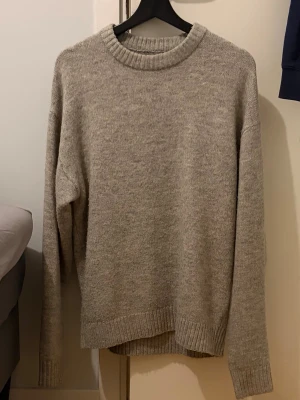 Ljusgrå stickad tröja - Säljer en grå stickad tröja i mycket fint skick. Den är storlek M men passar även L.