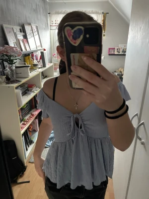 Ljusblå offshoulder blus med knyt - Supersöt ljusblå blus från Lager157 med offshoulder och volangärmar. Toppen har knyt framtill och en luftig, flowy passform. Perfekt för varma dagar och ger en romantisk vibe till outfiten.