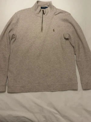 Beige half zip tröja från Polo Ralph Lauren - Används aldrig är i toppskick strl L. Inköpt för något år sen hsr ej kvitto kvar tyvärr