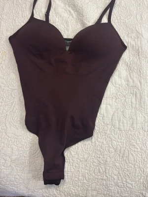 Vinröd body med smala axelband - Populär body från hm!! Jättefin o kan kläs upp och ner, priset kan diskuteras!