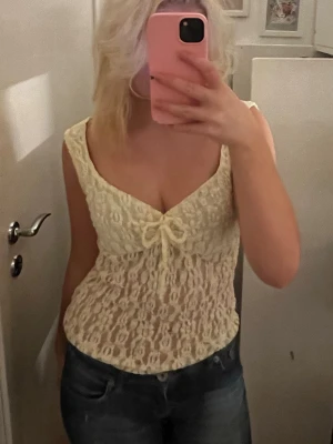 Gul spetstopp  - Säljer en krämvit blus från Nelly med  spets med blommönster. Nästan aldrig använt💗