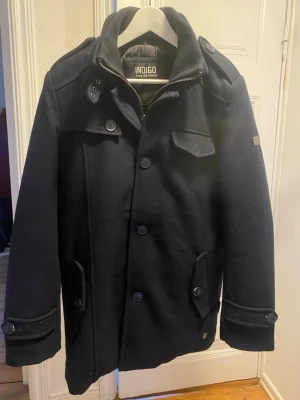 Mörkblå Indicode Jacka - Hej, säljer ny en helt ny jacka från Indicode då det var fel storlek och är där med aldrig använd. Jackan är både snygg och bekväm och är perfekt nu under vintern men också till våren. Färgen är blå och storleken är M. Hör av dig vid minsta fundering.  Ny pris: 1849 kr