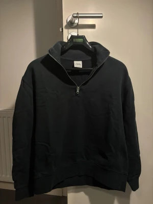 Mörkgrön half zip tröja från Zara - Säljer en svart långärmad tröja från Zara med half zip-dragkedja och hög krage. Enkel och stilren design som funkar till det mesta.