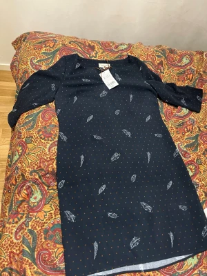 Grain de Malice Navy Blue Dress - Beautiful navy blue dress from Grain de Malice, brand new with original tags attached. Features a subtle dotted pattern with delicate feather print details. Comfortable, casual-elegant style that works great for everyday wear or dressed up with accessories. Brand: Grain de Malice Size: EU 38 Color: Navy blue (Bleu Marine) Condition: New with tags Original price: €34.99 Style: Casual / chic / everyday Smoke-free home. Happy to answer questions 🌿 
