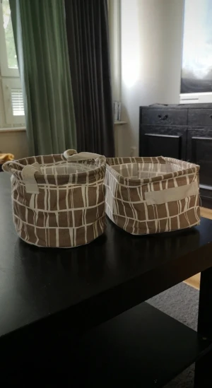 Brunbeigea tygkorgar med mönster - Två förvaringskorgar i tyg, en rund och en fyrkantig, i brun och beige med vitt rutmönster. Perfekta för att organisera småsaker. De går att veckla ihop. Korgarna är 18x18cm och 20x16cm med ett djup på 14cm på båda korgarna