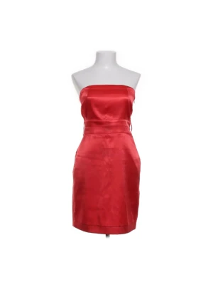 Röd axelbandslös kortklänning från Vila - Snygg röd axelbandslös klänning från Vila i kort modell. Klänningen har en slät framsida och smockad rygg för extra komfort. Tillverkad i glansigt satinliknande material som ger en lyxig känsla. Perfekt för dig som vill sticka ut med en enkel men elegant look.