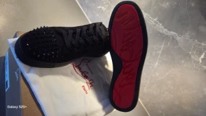 Christian Louboutin skor  - Lyxiga och riktigt eye-catching sneakers från Christian Louboutin! Helt svarta med ikoniska spikes på tån som ger en brutal och exklusiv look. Perfekt för dig som vill sticka ut med stil – både till vardags och fest.