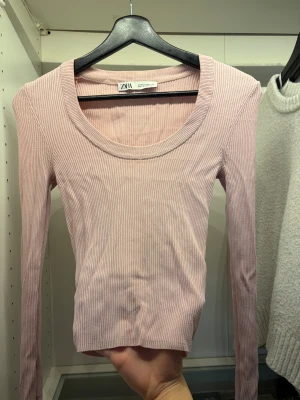 Ljusrosa ribbad topp från Zara - Supersnygg ljusrosa långärmad topp från Zara med ribbad struktur och rund halsringning. Små fläckar nere vid midjan (bild 2) syns dock inte mycket längre bort ifrån och borde gå ut i tvätten med t.ex galltvål. Annars bra skick 