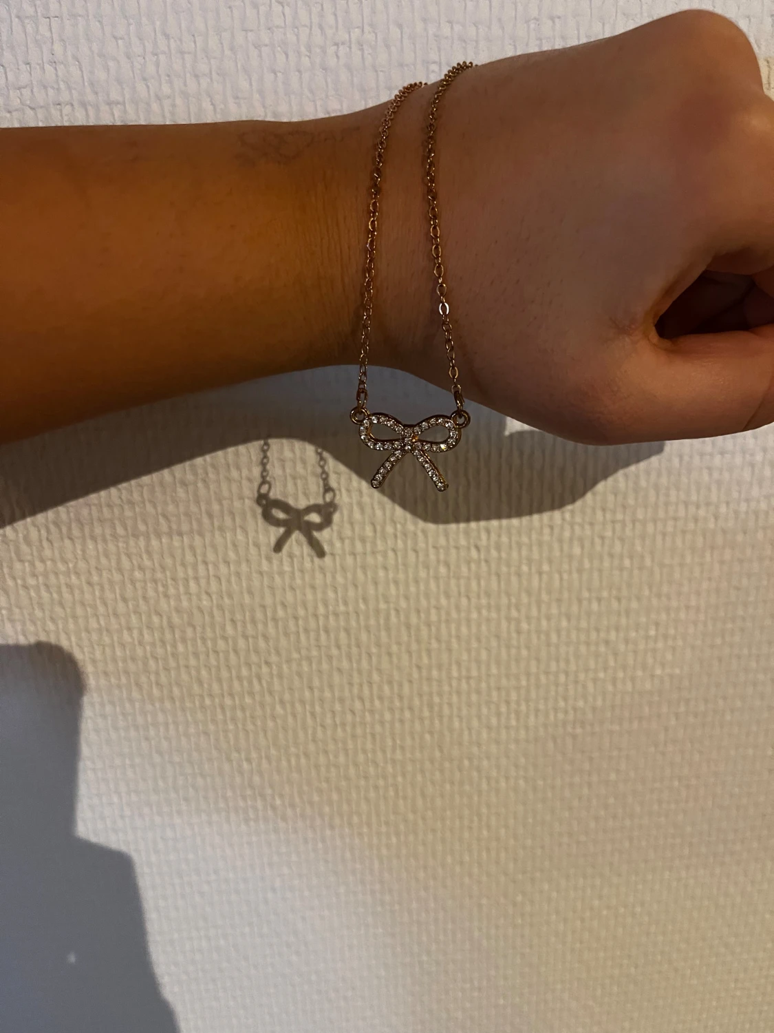 Guldfärgat halsband med rosett och stenar - 1