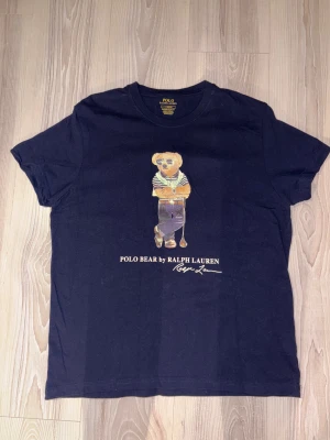 Marin blå Polo Bear t-shirt från Ralph Lauren - Oanvänd men tvättad en gång. Tyckte inte passformen var som jag hade tänkt att den skulle vara. 