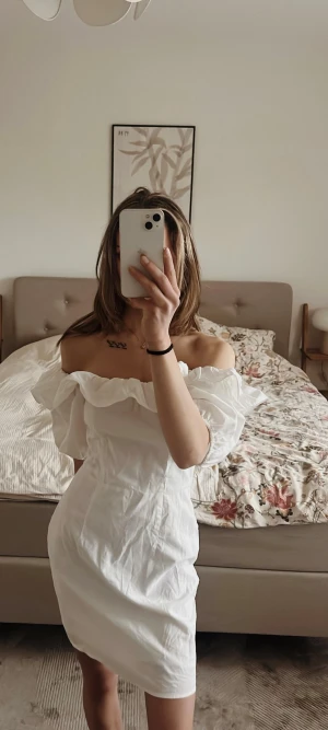 Söt vit studentklänning/linneklänning!  - Superfin vit kortklänning med ärmar som antingen kan bäras offshoulder eller över axlarna. och s volanger upptill. Den är figursydd och därför något utsvängd nedtill, håller formen. Inga defekter!  