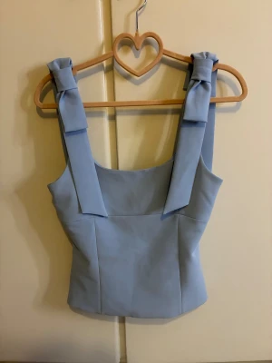 Ljusblå linnetopp med rosett - Supersöt och trendig ljusblå linnetopp från Zara, använd några få gånger. I jätte bra skicka och inga defekter. Pris kan diskuteras💗