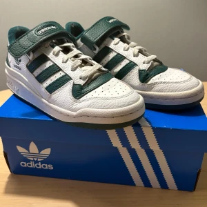 Adidas Forum Low - Använda men fortfarande bra skick, defekter finns vid hälen, skosnörena och sulan är även smått smutsig/missfärgad, kan skicka med nya skosnören om så önskas💞Skickas i orginalboxen!  Storlek 40. Köpt för 1145 för något år sedan😇