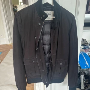 Valstar - Valstarino suede padded down. ﻿Storlek 48 - Navy Blue. ﻿Butikspris 18000 kronor. ﻿ ﻿﻿https://valstarmilano.com/en-ue/products/valstarino-dark-blue  Jackan är så gott som ny och har inga fläckar eller märken.  90% gåsdun, 10% gåsfjädrar. - Producerad i Italien - Tillverkad utav exklusiv getmocka. - Stängs med dragkedja och knappar. - Två utanpåliggande framfickor med knapp samt två innerfickor - Ribbstickad mudd vid krage samt ärm- och plaggslut.