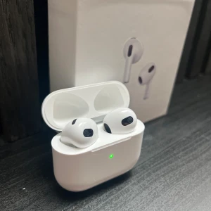 AirPods 3 - Apple AirPods 3 i mycket fint skick, komplett med originalförpackning. Trådlösa hörlurar med laddningsetui, lång batteritid och smidig anslutning till iPhone och andra Apple-enheter. Inga synliga repor eller skador, fungerar utmärkt. De är inte dock äkta men de är rena och fina och ser ut som äkta.