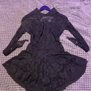 Konståkningsklänning med spets och lång ärm - Supersnygg svart konståkningsklänning i spets med långärmade ärmar och blommigt mönster.💗  Finns ett litet hål på insidan av ena ärmen (se bild) storleken är s/m