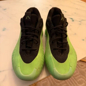 Adidas sneakers i svart och grönt - Säljer ett par Adidas sneakers med svart ovandel i mesh och syntet samt grön sula och detaljer. Skorna har snörning och en cool, futuristisk design med ventilerande sidor och Adidas-logga bak. Perfekta för dig som vill sticka ut med din stil. Behövs bara ny innersula. 