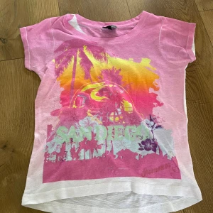  San Diego t-shirt  - En rosa T-shirt i bomullstyg💕 Den har ett tunt tyg men den är skön o ha på sig💓. Tyvärr står det ingenting om storlek i den men den är runt 146- 160