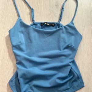 Blå linnetopp från Bik Bok - Säljer en enkel och stilren blå linnetopp från Bik Bok i storlek XS. Toppen har smala axelband och rak halsringning, topp skick och använd fåtal gånger
