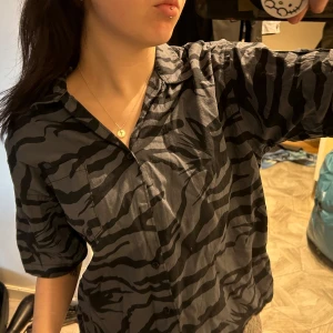 Croppat skjorta med ränder - Snygg kortärmad skjorta med coola ränder i storlek M. Skjortan e avklippt för att få en mer croppad stil. 🌺