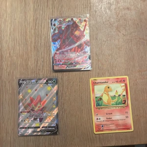 Pokémonkort: Coalossal VMAX, Eldegoss V, Charmander - Tre coola Pokémonkort! Få den klassiska Charmander, den glittriga Eldegoss V och den mäktiga Coalossal VMAX. Perfekt för dig som samlar eller vill boosta din lek med unika och färgstarka kort. Passar både nya och erfarna Pokémonfans!