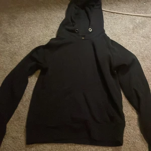 Mörkblå hoodie med huva - En klassisk mörkblå hoodie med huva och långa ärmar. Tröjan har en enkel design utan tryck eller mönster, och är perfekt för en avslappnad stil. Mjuk och bekväm, passar till många olika outfits.