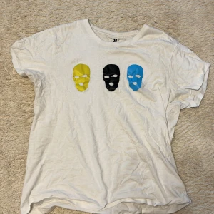 Vit t-shirt med färgglada masker Roly - 1.cuz T-shirt Han hade den på sig den i sin Malmöfestival konsert. Bra kvalité storlek M aldrig andvänd