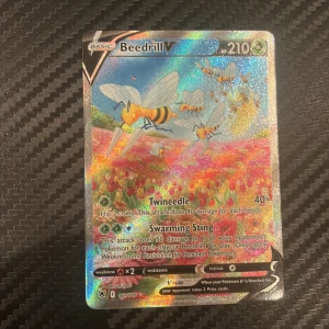 Beedrill V. Graderad kostar 1600 - Cool och glittrig Pokémonkort med Beedrill V! Perfekt för samlare och spelare som vill boosta sin lek med en stark och snygg karta. Kortet har färgstark design och är i fint skick – ett måste för alla Pokémon-fans!