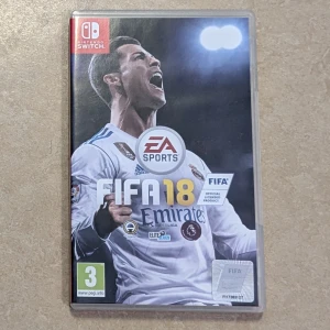 FIFA 18 Nintendo Switch - FIFA 18 till Nintendo Switch i fint skick. Upplev realistisk fotboll med officiella lag, spelare och turneringar. Perfekt för både solo- och flerspelarläge. Omslag och fodral är i gott skick, inga synliga skador.