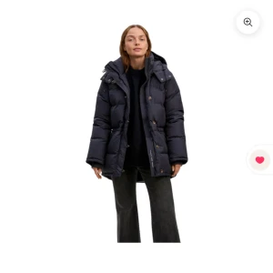 Boomerang jacka - Säljer en mörkblå boomerang jacka med stor huva och knappar framtill. Jackan har en längre modell, breda kanaler och dragsko vid huvan. Perfekt för kalla dagar och riktigt skön att bära. Fickor på sidorna och klassisk pufferstil. Nypris 5.999kr storlek xxs men passar xs okså