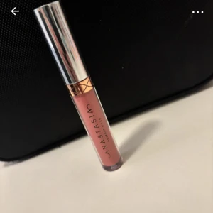 Anastasia Beverly Hills liquid matte lipstick  - Snyggt liquid matte lipstick från Anastasia Beverly Hills i en mjuk rosa nyans. Kommer i en stilren tub med silvrigt lock och guldiga detaljer. Perfekt för att ge läpparna en matte finish och en hint av färg. Färg: dusty rose