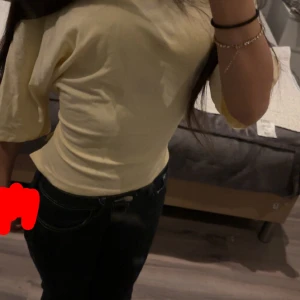 Gul omlottopp med knyt i ryggen/open back tie tee  - Säljer en ljusgul topp med korta ärmar och snygg omlottdesign. Toppen har öppen rygg med knytband som ger en cool och trendig look. Passformen är slim och materialet känns mjukt  och bekvämt, perfekt för vår och sommar.storlek xs 