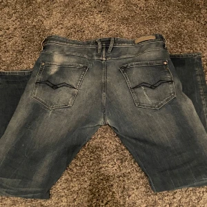 Blå Replay jeans raka - Säljer ett par blå Replay jeans i klassisk tvätt med snygga slitningar och kontrastsömmar. Jeansen har fem fickor, raka ben och normal passform. Bakfickorna har Replay-logga och coolt broderi. Perfekta för dig som gillar en avslappnad men stilren look. Storlek w36 och L34😊