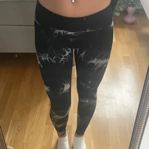 Svarta träningsbyxor  - Säljer ett par träningsbyxor i fint mönster, de sitter perfekt och är sköna att ha på sig. De är stretchiga och har en scrunch på rumpan som gör att man får ett typ av lyft