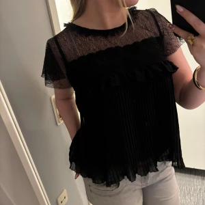 Svart blus - Säljer en super snygg svart blus från ZARA med transparent spets upptill och korta ärmar! 