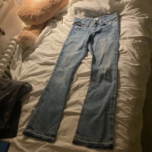 Bootcut jeans från Gina Tricot ljusblå - Ljusblå bootcut jeans från Gina Tricot i storlek 164. Jeansen har slitna detaljer vid knäna, fransiga benslut. Klassisk femficksmodell med dragkedja och knapp. Perfekta för dig som gillar en avslappnad och cool stil.💕