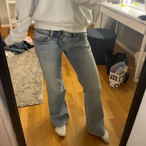 Blå bootcut jeans med fickdetaljer - Säljer ett par ljusblå jeans med bootcut passform och snygga fickor med knapp bak. Jeansen är uppsydda så passar mig som är 160cm