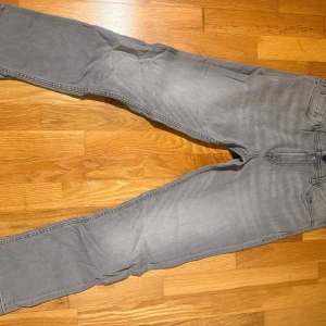 Grå jeans W30 L30 - Snygga grå jeans med klassisk femficksdesign och raka ben. Jeansen har en neutral grå tvätt och är tillverkade i ett mjukt bomullsmaterial med lite stretch. Perfekta för dig som gillar en enkel och stilren look.