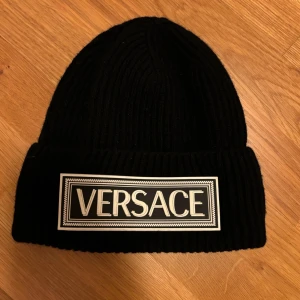 Versace mössa - Hej, säljer nu en Versace mössa i färgen svart med snyggt märke. Mössan är självklart äkta och i väldigt bra skick. Perfekt nu till vintern. Mvh Ture
