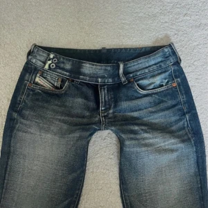 Lågmidjade diesel jeans  - Snygga blå jeans från Diesel med coola slitningar och tvättad look. 